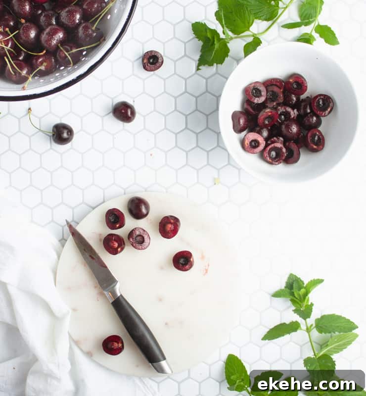 cutting board with halved, pitted cherries
