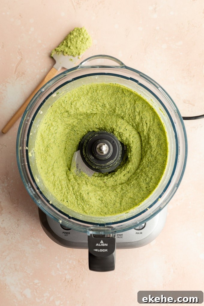 Green hummus whipped up in a food processor bowl.